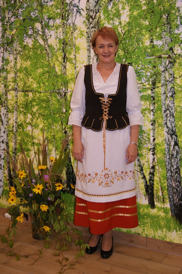 Barbara Klimek  w stroju borowiackim na tle brzóz