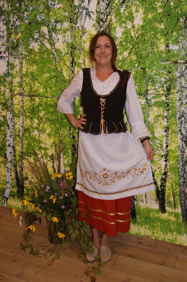 Magdalena Sowińska-Fierek  w stroju borowiackim na tle brzóz